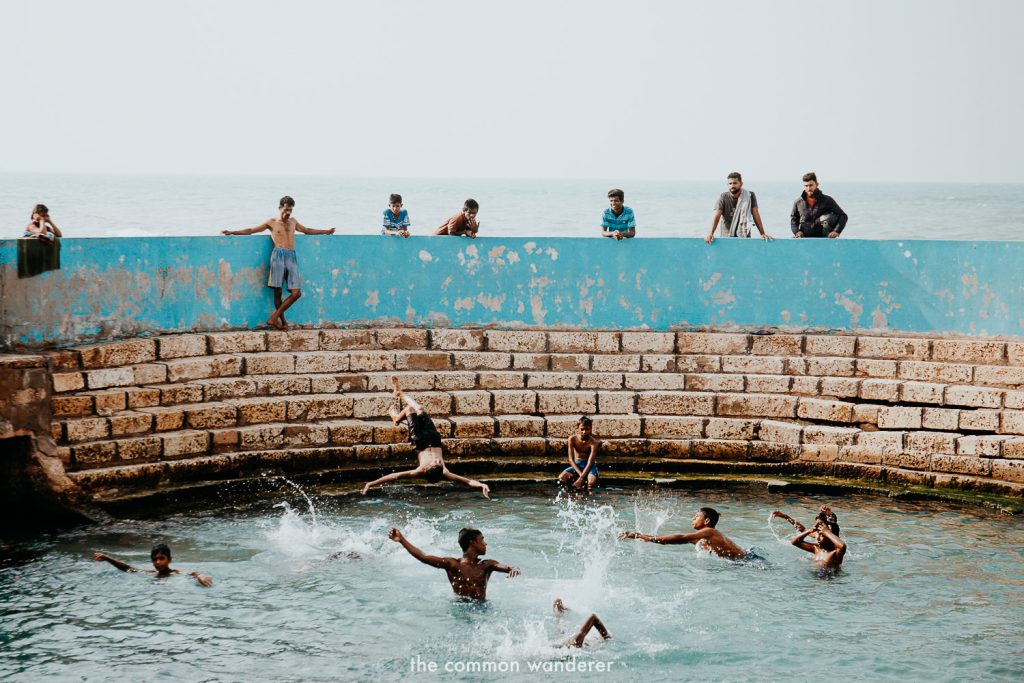 Young people swimming in Keerimalai Pond, enjoying a carefree moment of happiness.